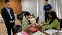 Foto da consulesa geral da China mostrando um livro para a vice-reitora da Ufes