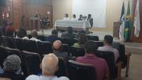 Foto da mesa principal da solenidade e de parte dos presentes no auditório
