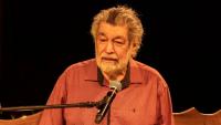 Foto do maestro Wagner Tiso sentado à frente de um teclaro