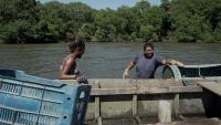 Cena do documentário na qual aparecem duas mulheres ao lado de barcos na região do mangue