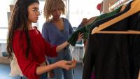 Imagem de duas mulheres escolhendo roupas em uma arara