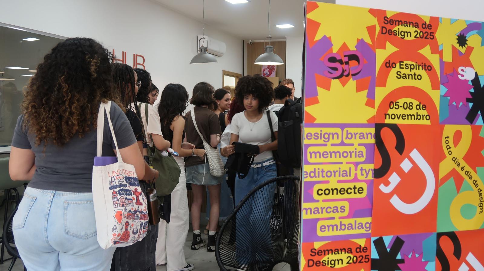 Foto da entrada do evento com várias pessoas circulando