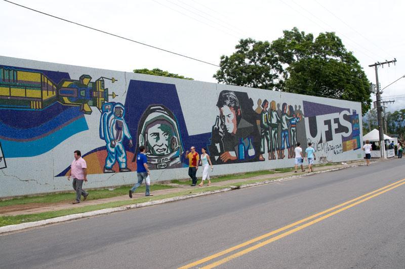 Foto do mural da Ufes com pessoas andando na calçada