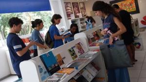 A foto mostra estudantes visitando a livraria da Ufes e olhando os livros