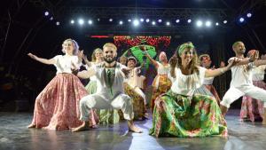 Na foto, integrantes do grupo Andora estão agachados e com mãos estendidas durante dança