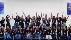 Foto dos integrantes da liga reunidos, todos vestindo camisas pretas e com os braços para cima, em comemoração