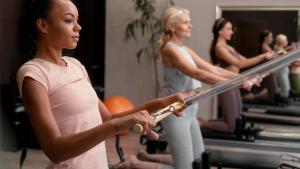 Exercício de Pilates Imagem de três mulheres em pés, fazendo um exercício em um aparelho de pilates