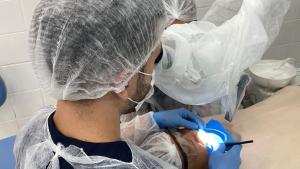 Foto de um dentista atendendo a uma pessoa no consultório