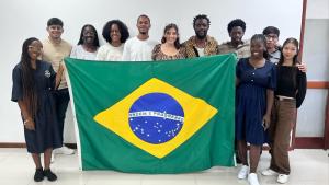 Foto dos estudantes reunidos segurando uma bandeira do Brasil 