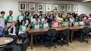 Foto de todo o grupo com a vice-reitora Sonia Lopes na sala de reuniões da Reitoria