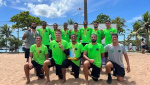 Equipe de handebol posa para foto com medalhas e troféu
