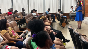 Foto da vice-reitora falando aos trabalhadores no auditório