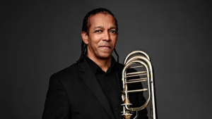 Foto do trombonista norte-americano Darrin C. Milling em pé, segurando o trombone