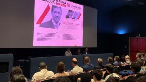 Foto da aula magna com o palestrante e dos debatedores à frente, na mesa principal