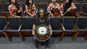 Foto do músico Luccas Martins segurando o handpan e o Quarteto Zuri