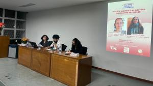 Foto da mesa com as duas pesquisadoras e um mediador