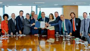 Foto de todas as autoridades presentes na sala de audiência, mostrando a portaria assinada