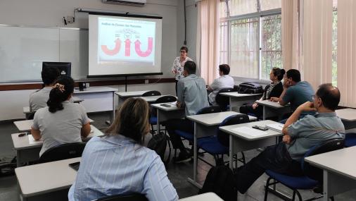 Grupo de pessoas assistindo a uma apresentação em uma sala