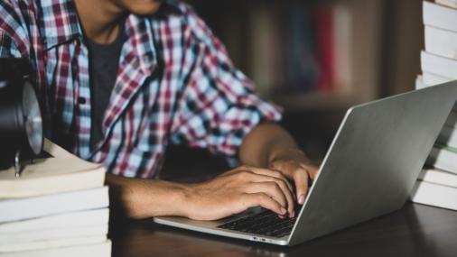 Imagem de um estudante digitando em um notebook
