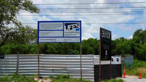 Foto dos tapumes que cercam o canteiro onde começou a obra